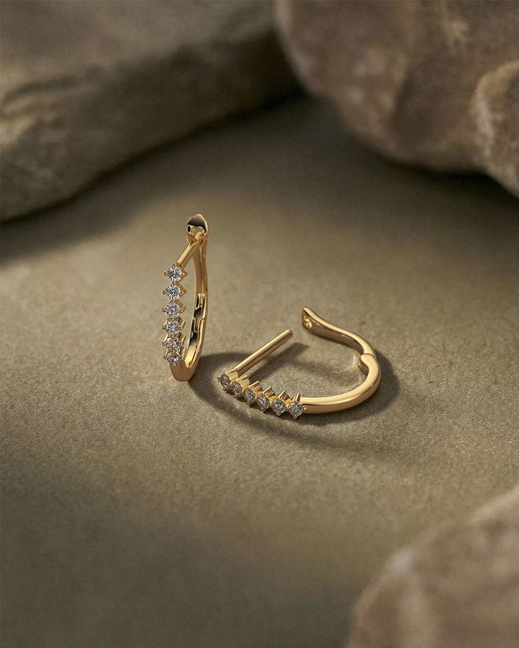 Pair of curved 18K gold hoops set with a line of crafted diamonds