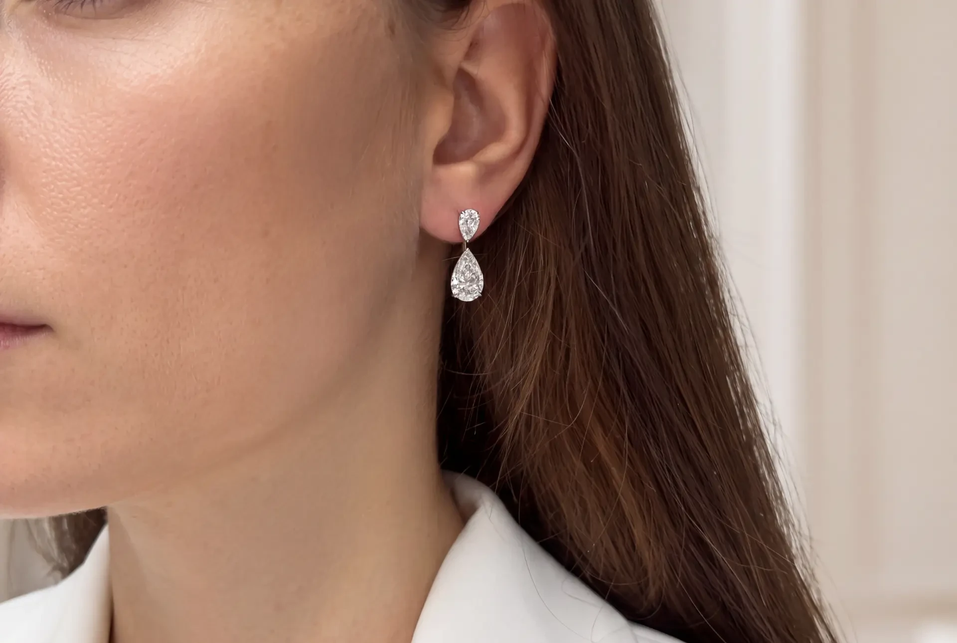 Pear-cut diamond drop earring worn at the ear