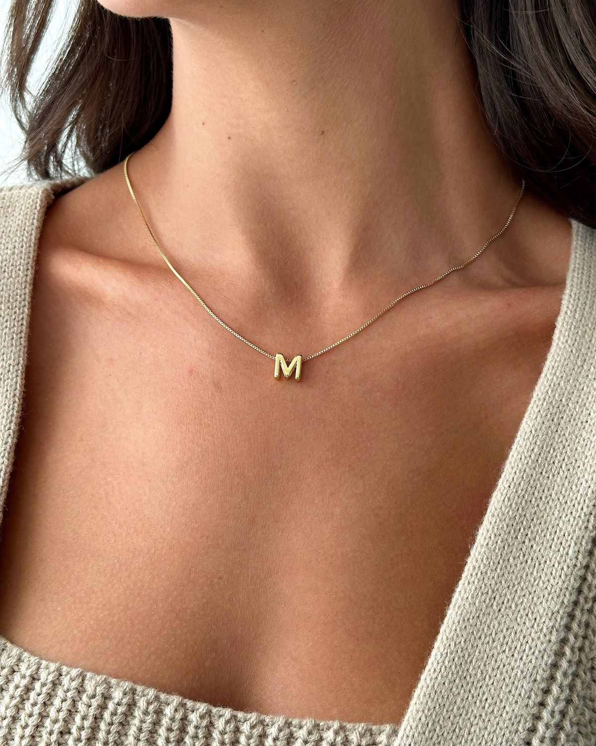 Gold initial pendant worn