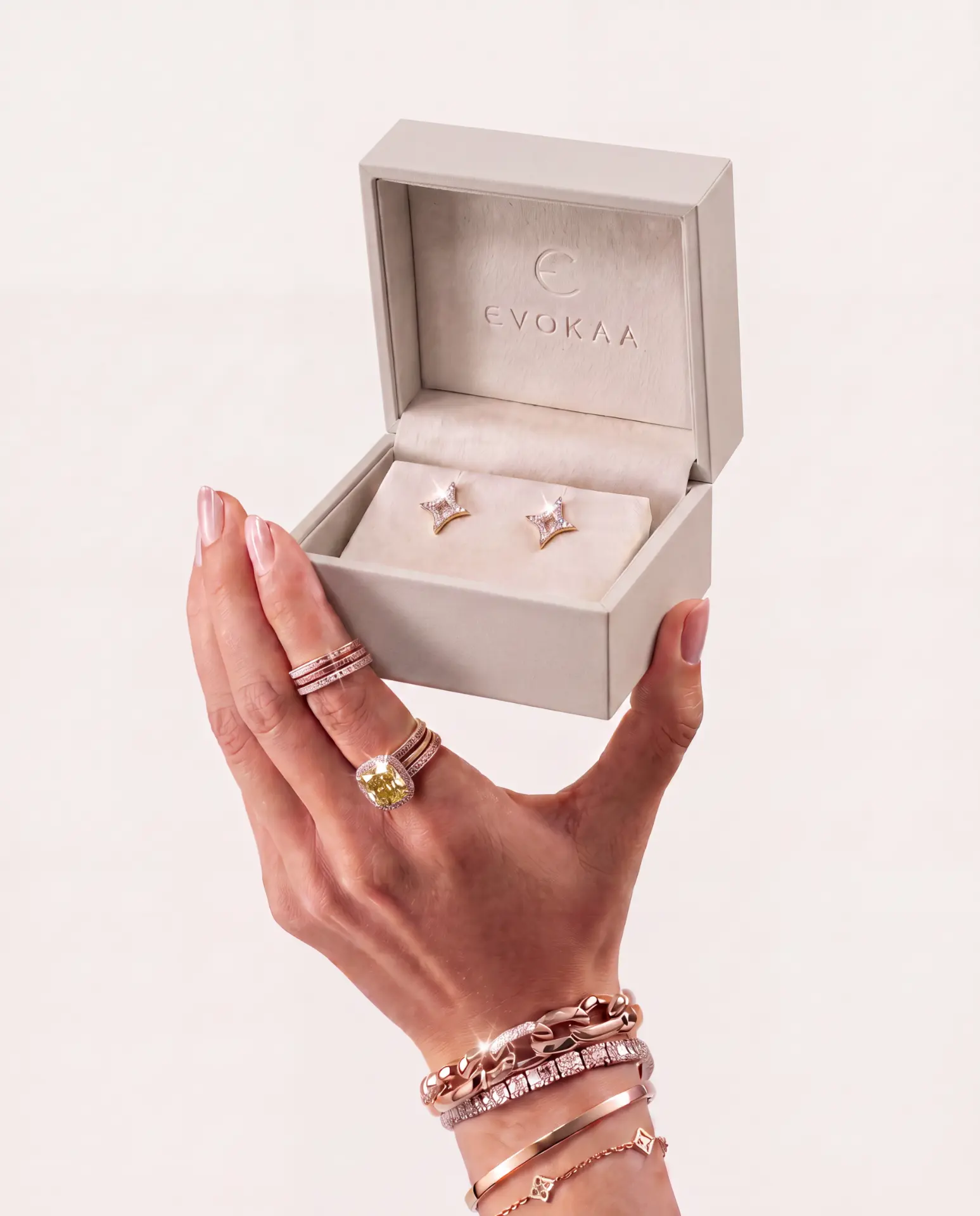 A hand holding an open Evokaa box of diamond studs