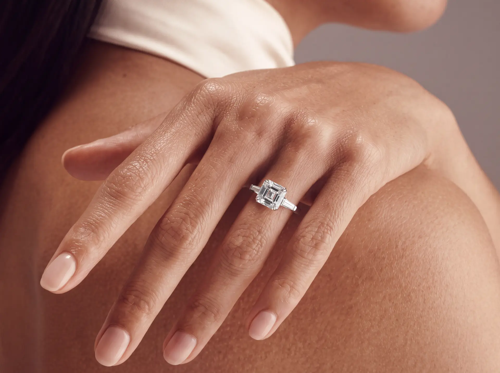 Emerald cut solitaire ring worn on the hand